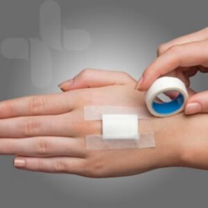 Microporous paper tape securing a dressing on the back of a hand