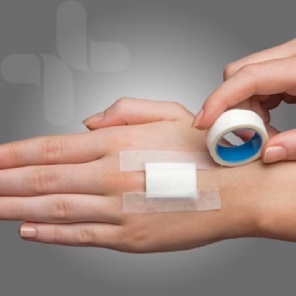 Microporous paper tape securing a dressing on the back of a hand