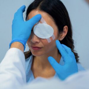 First aider in gloves placing a sterile eye pad over a closed eye